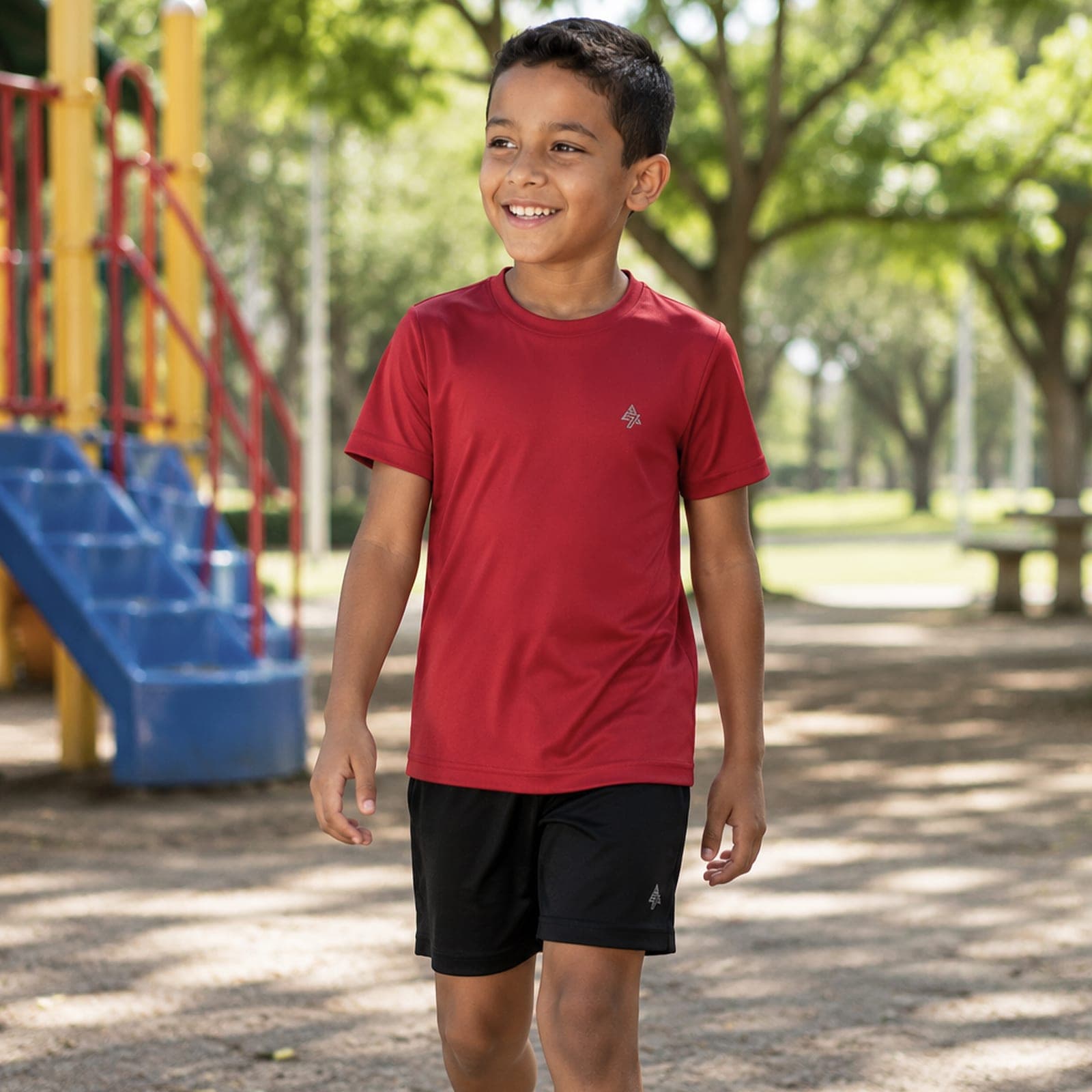 Criança vestindo camiseta dry-fit vermelha Adon7 em playground